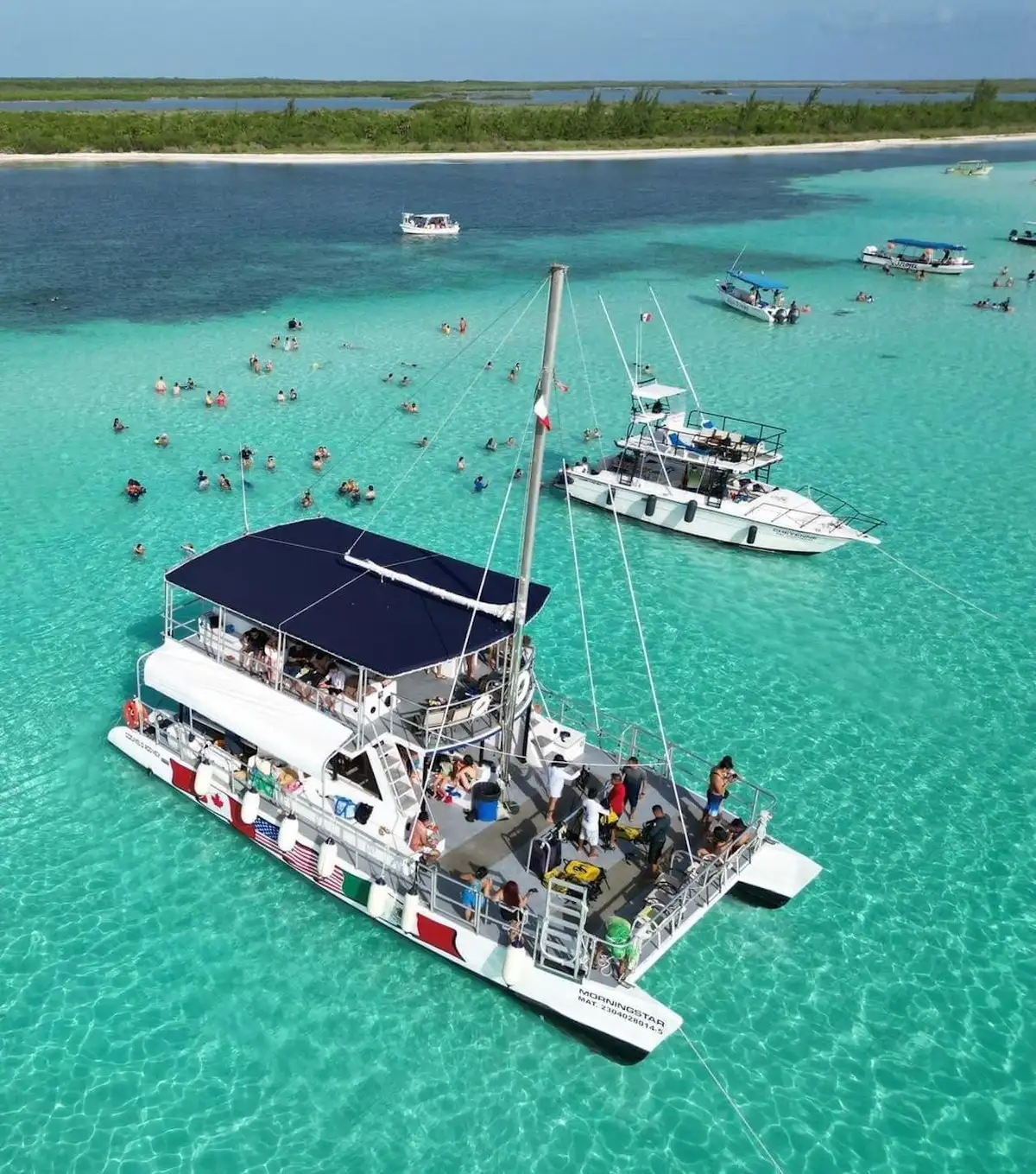 Catamaran sailing at sunset on a Cozumel boat tour past the turquoise shallows of El Cielo